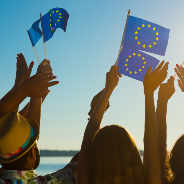 Junge Menschen halten Europaflaggen in die Luft